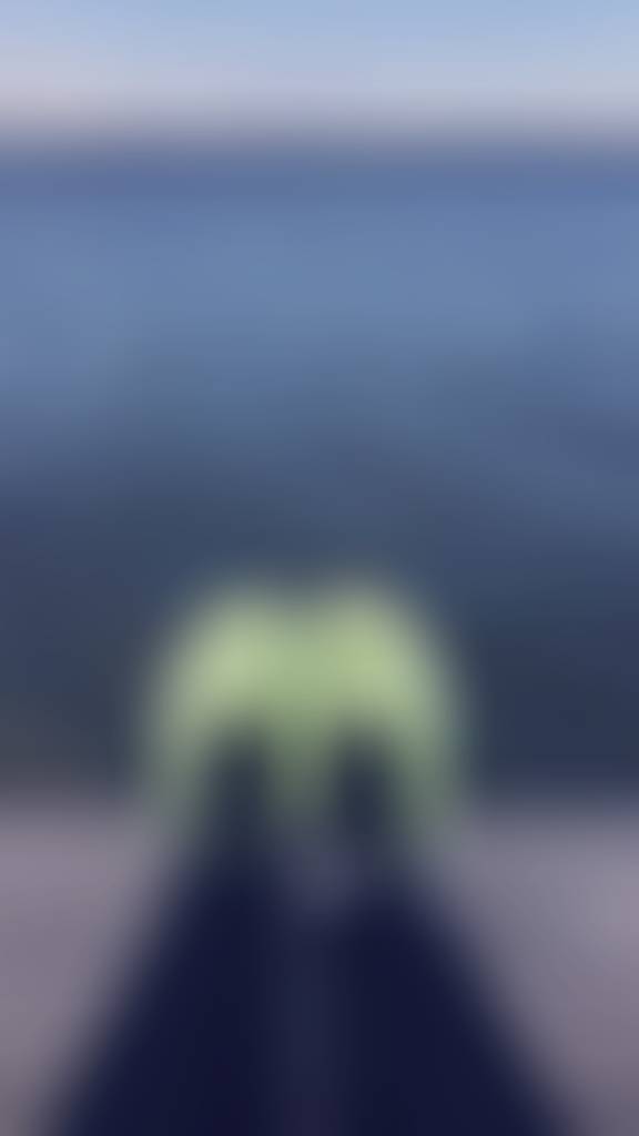 The warm wooden planks of the dock press gently against the backs of my thighs. My legs st