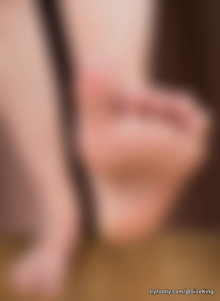 A raised sole, toes curled, big toe broad and waiting. The rest of the foot stays blurred 